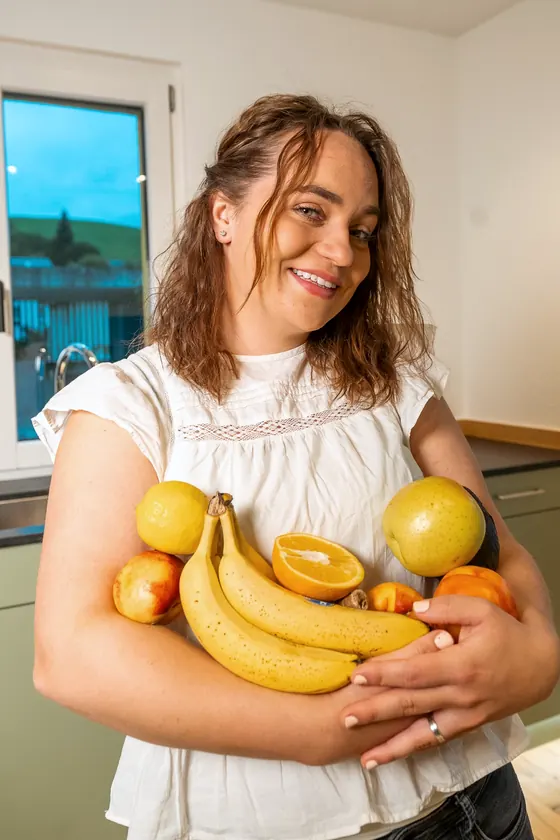Norina hält Bananen, Orangen und Äpfel im Arm