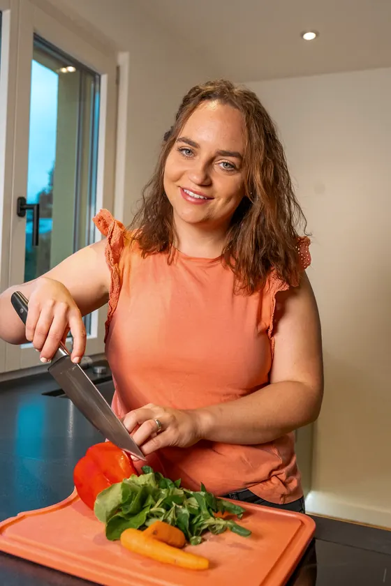 Norina schneidet Peperoni und Rüebli auf einem Brett